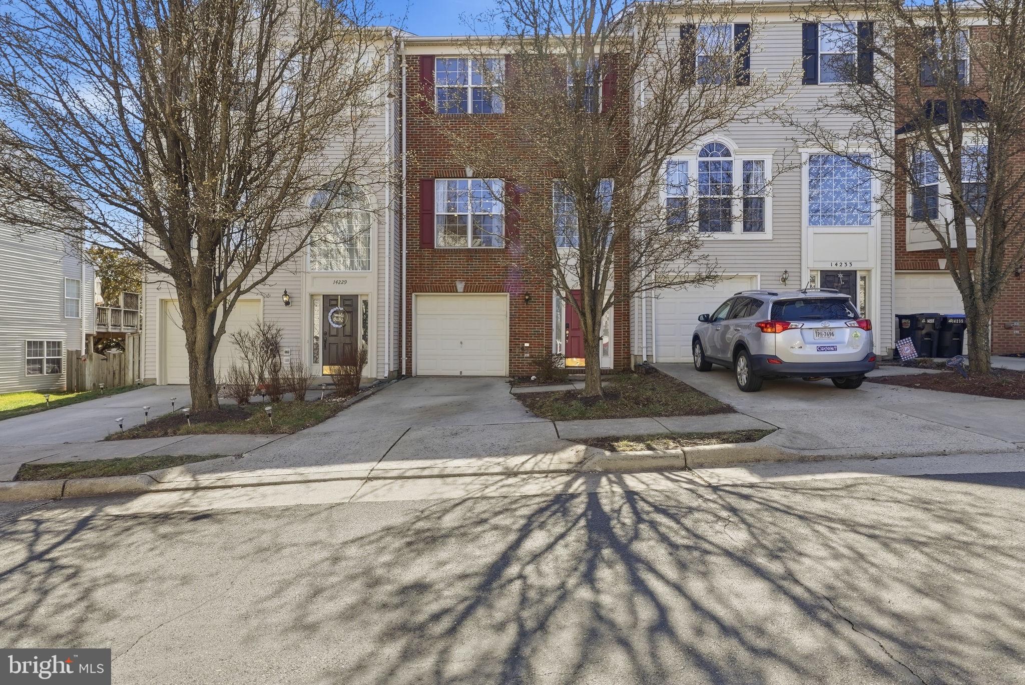 14231 Hunters Run Way Gainesville, VA 20155 - Photo 6 of 41 a view of a parked cars in front of brick building