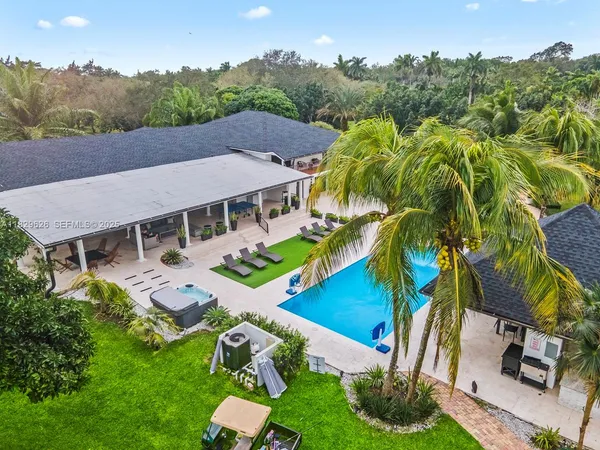 an aerial view of residential houses with outdoor space and trees