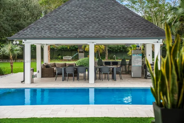 a living room with furniture a chandelier and a floor to ceiling window