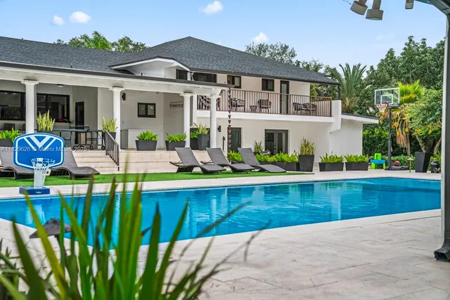a view of swimming pool with outdoor seating and a garden