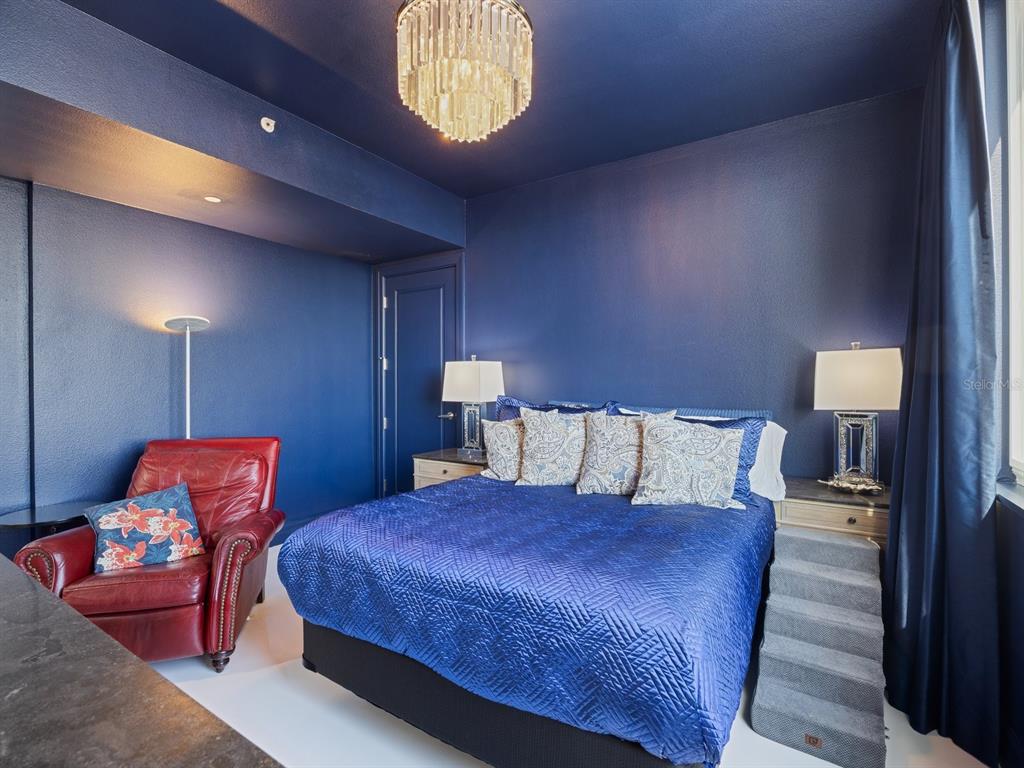 331 Cleveland Street, Unit 1101 Clearwater, FL 33755 - Photo 14 of 77 a bed room with a bed and a lamp