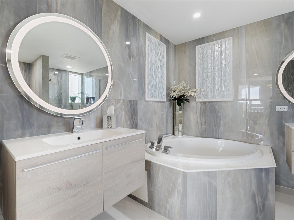 331 Cleveland Street, Unit 1101 Clearwater, FL 33755 - Photo 37 of 77 a bathroom with a sink a mirror and a bathtub