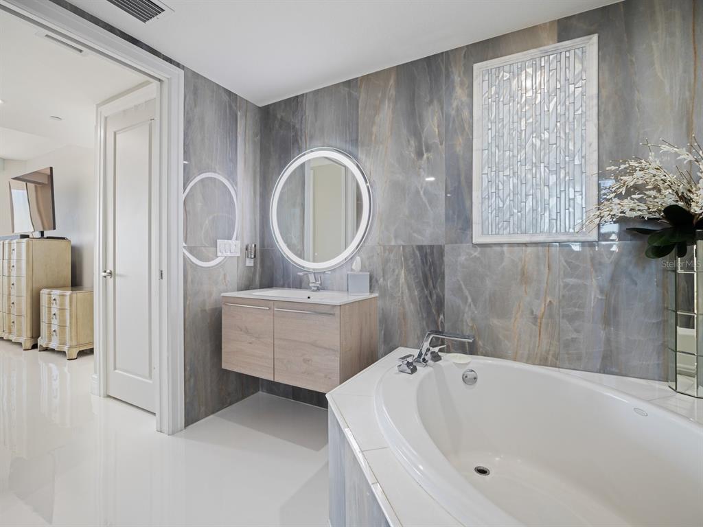 331 Cleveland Street, Unit 1101 Clearwater, FL 33755 - Photo 40 of 77 a bathroom with a tub sink and mirror