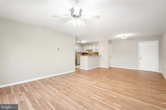 a view of a livingroom with a chandelier fan and wooden floor