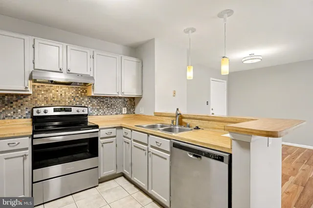a kitchen with a sink stove and cabinets
