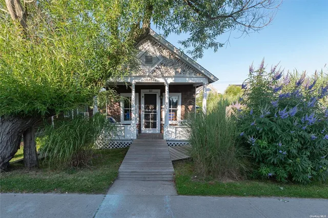 a front view of a house with yard and green space