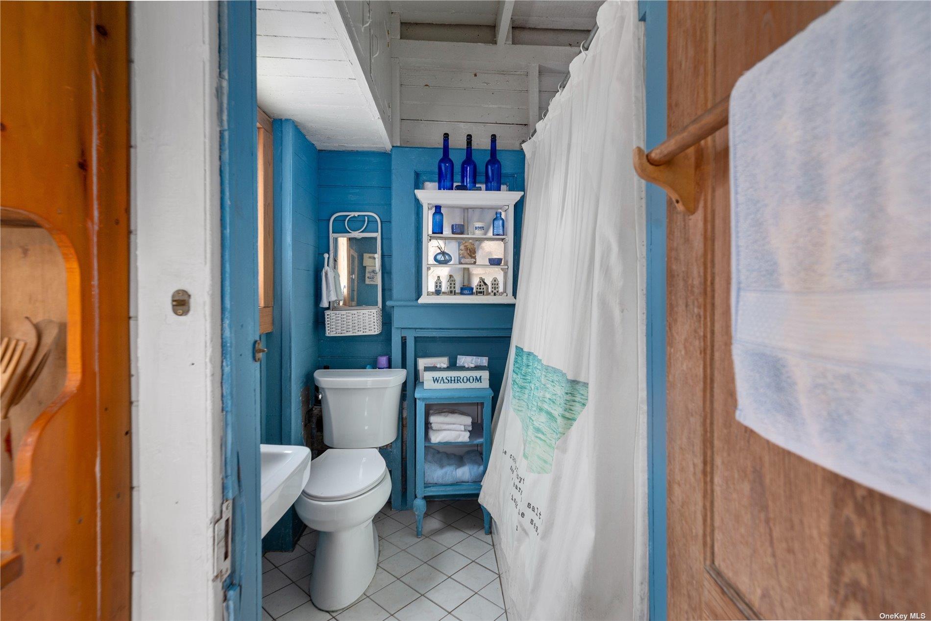 20 Ocean Road Ocean Beach, NY 11770 - Photo 12 of 19 a bathroom with a toilet sink and shower curtain