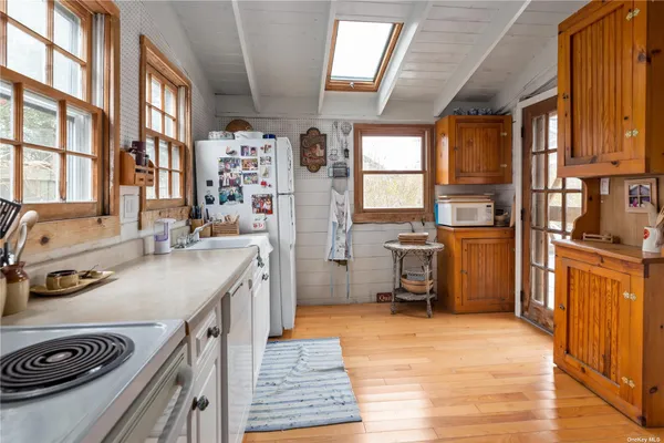 a kitchen with stainless steel appliances granite countertop a refrigerator a sink dishwasher a stove and a dining table with wooden floor