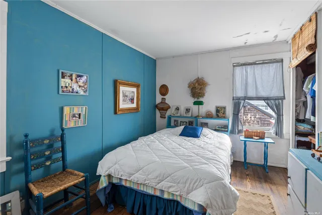 a bedroom with a bed wall painting and a window