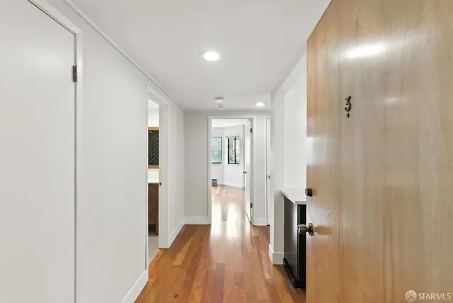 a view of a hallway with wooden floor