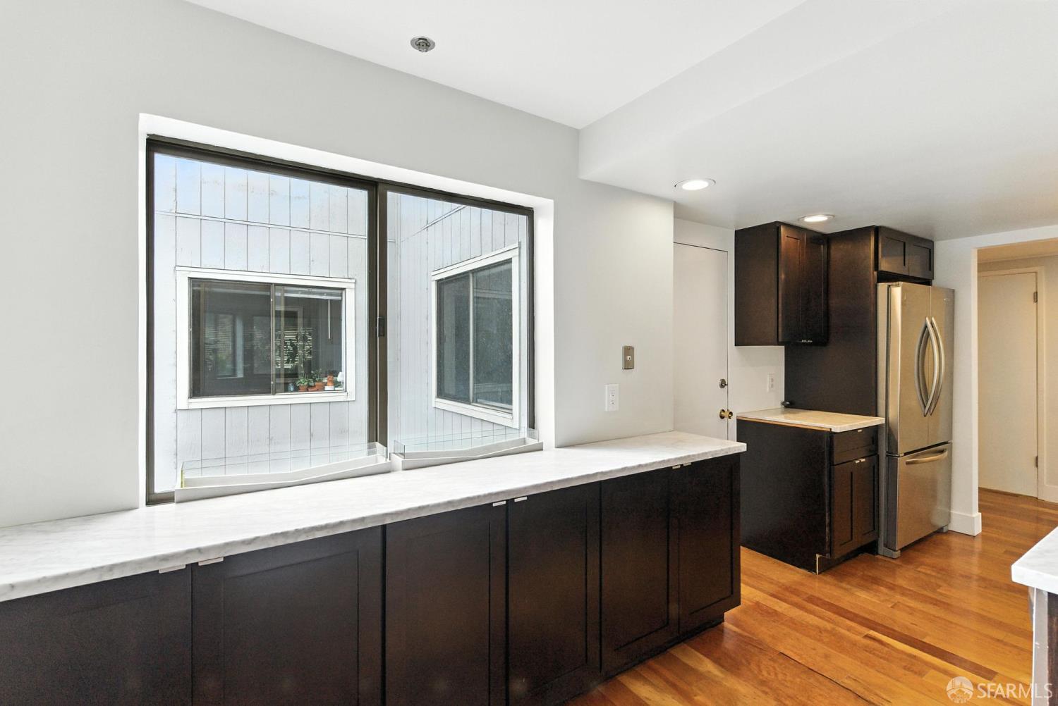 3256 16th Street, Unit 3 San Francisco, CA 94103 - Photo 5 of 16 a kitchen with stainless steel appliances granite countertop a refrigerator and a sink