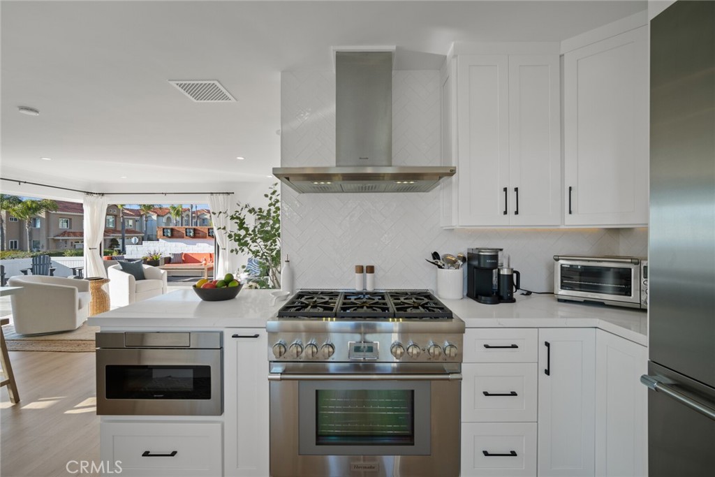 24272 Selva Road Dana Point, CA 92629 - Photo 15 of 59 a kitchen with a stove and white cabinets