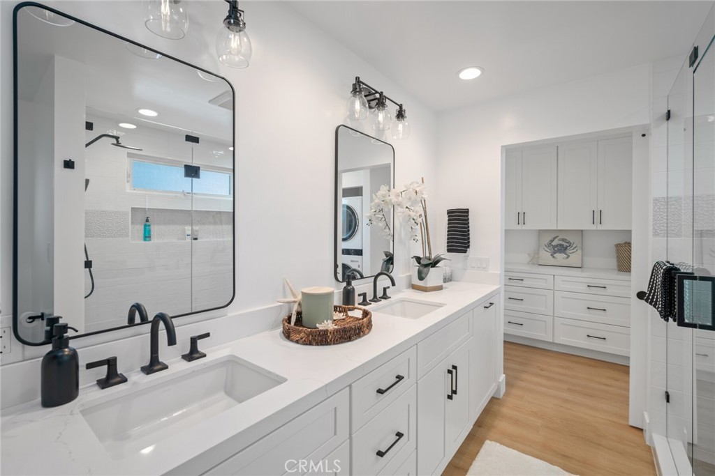 24272 Selva Road Dana Point, CA 92629 - Photo 22 of 59 a bathroom with double vanity sinks a vanity two mirror and a shower