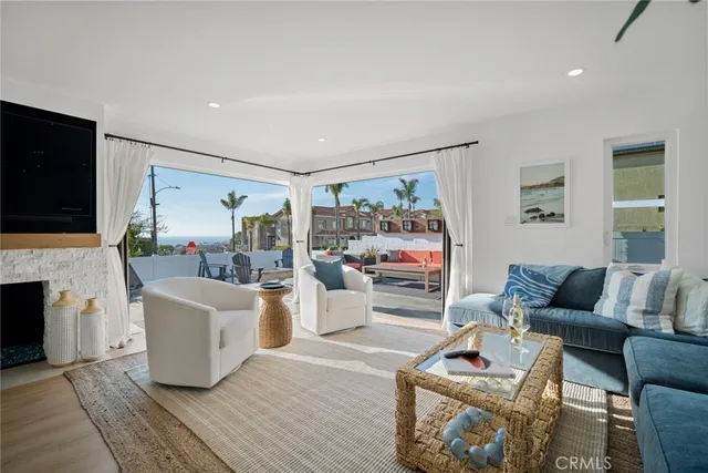 a living room with furniture a fireplace and a floor to ceiling window