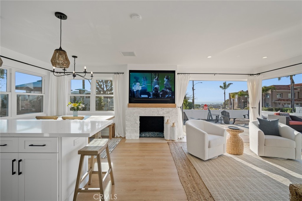 24272 Selva Road Dana Point, CA 92629 - Photo 7 of 59 a living room with furniture a flat screen tv and a fireplace