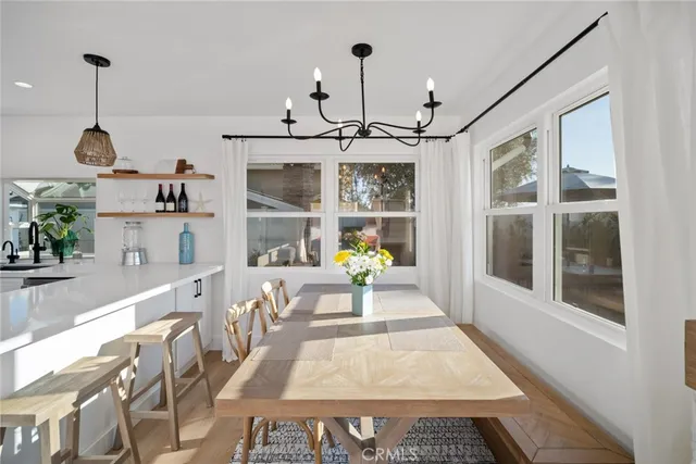 a very nice looking dining room with a large window and chandelier