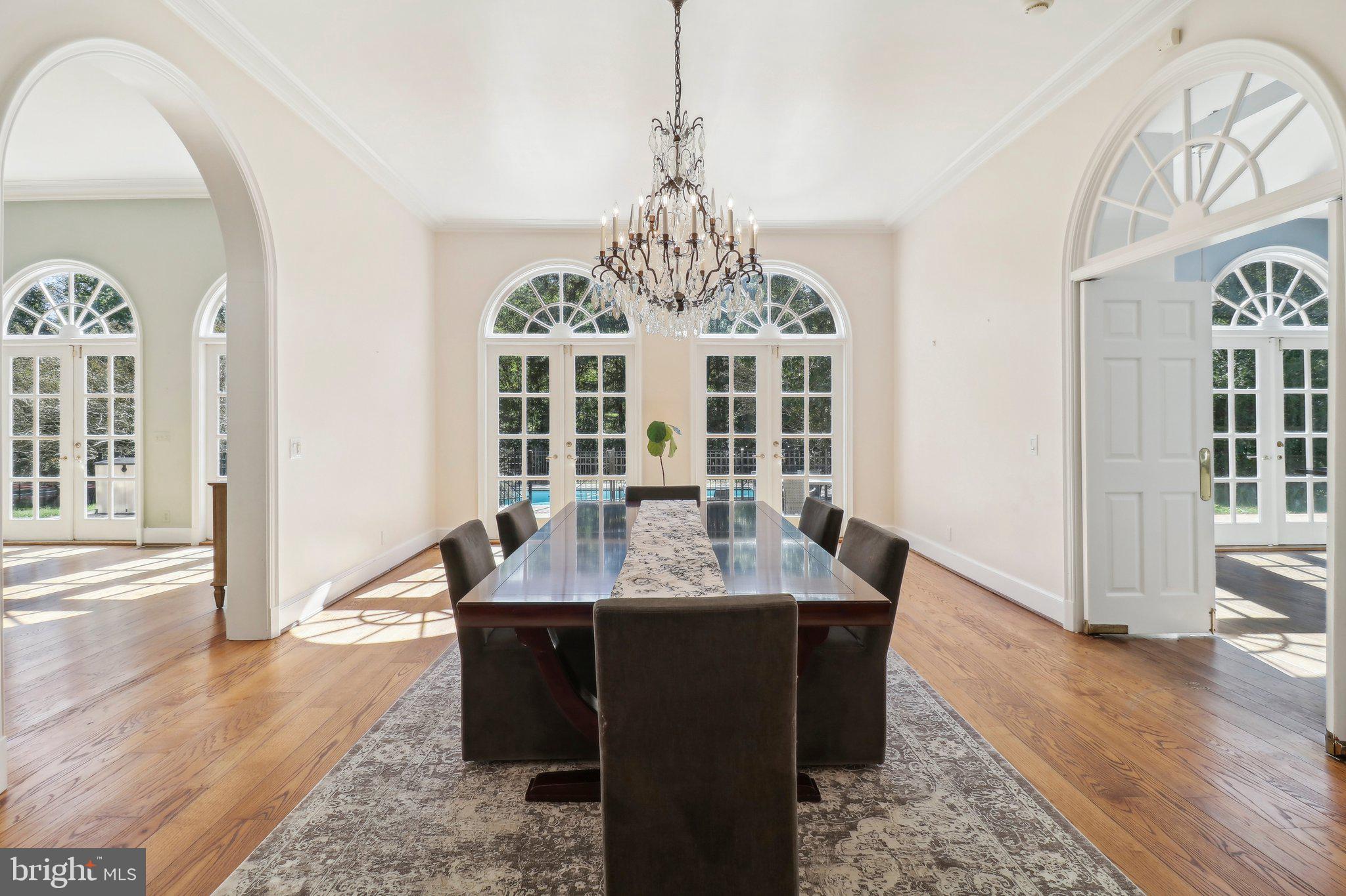 10650 Gunston Road Lorton, VA 22079 - Photo 21 of 73 a dining room with wooden floor a chandelier a wooden table and chairs