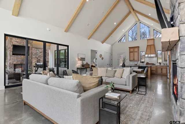 a living room with furniture a large window and a fireplace