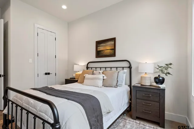 a bedroom with a bed and a lamp on the dresser