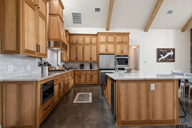 a kitchen with stainless steel appliances granite countertop a stove a sink and a microwave