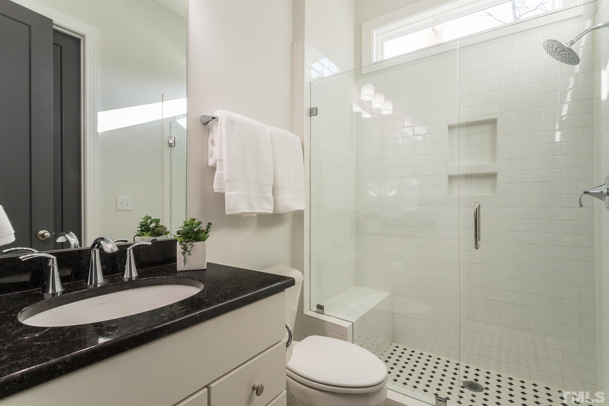 5601 Norcrest Street Raleigh, NC 27612 - Photo 25 of 41 a bathroom with a granite countertop sink a toilet a mirror and shower