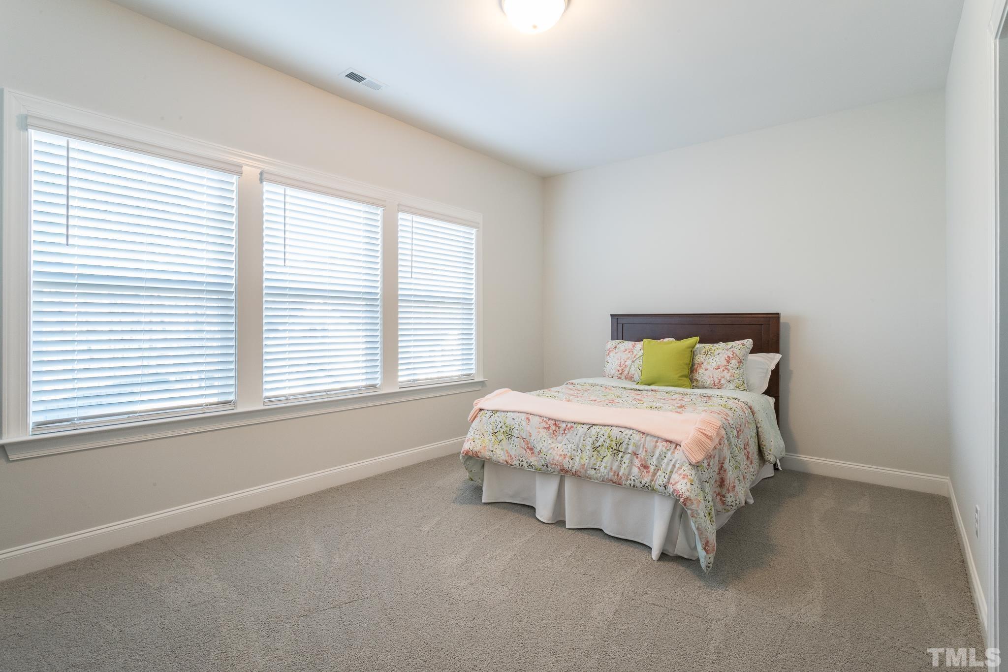 5601 Norcrest Street Raleigh, NC 27612 - Photo 31 of 41 a bed sitting in a bedroom next to a window
