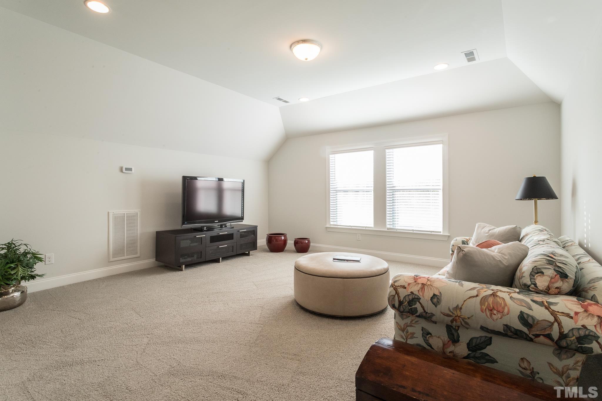 5601 Norcrest Street Raleigh, NC 27612 - Photo 36 of 41 a living room with furniture a flat screen tv and a window