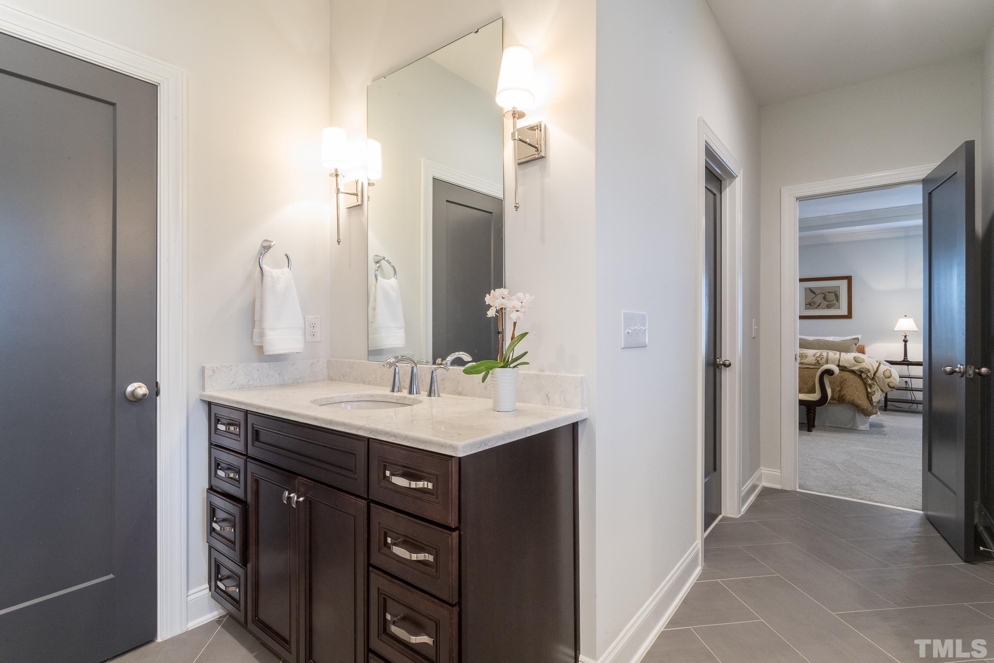 5601 Norcrest Street Raleigh, NC 27612 - Photo 37 of 41 a en suite bathroom with a granite countertop sink and a mirror