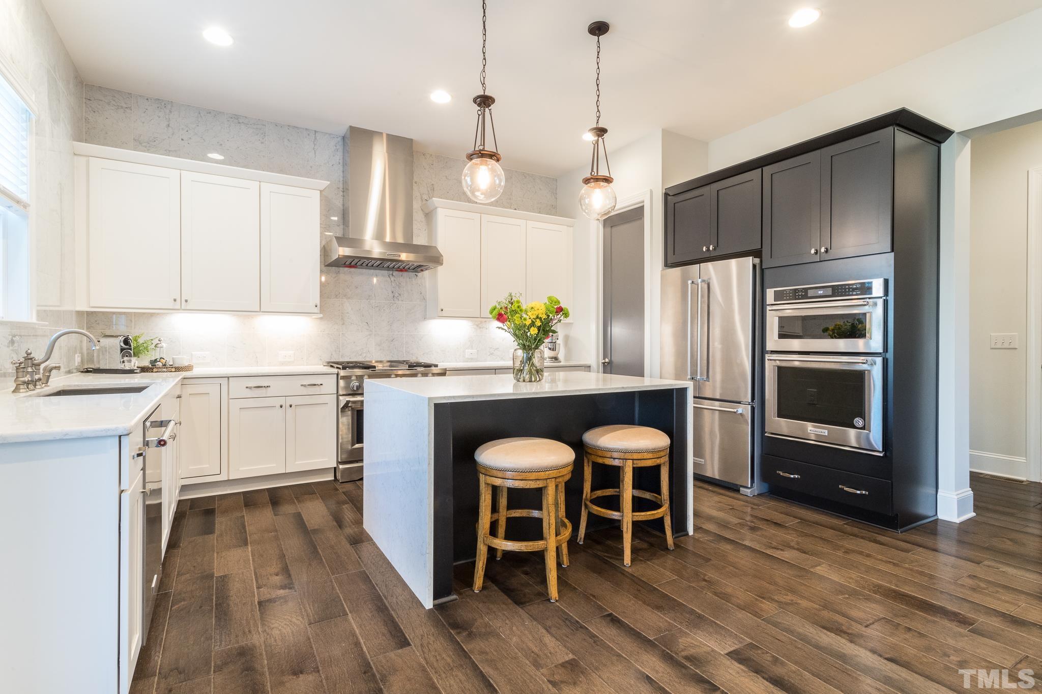 5601 Norcrest Street Raleigh, NC 27612 - Photo 4 of 41 a kitchen with stainless steel appliances kitchen island granite countertop a table chairs and a refrigerator