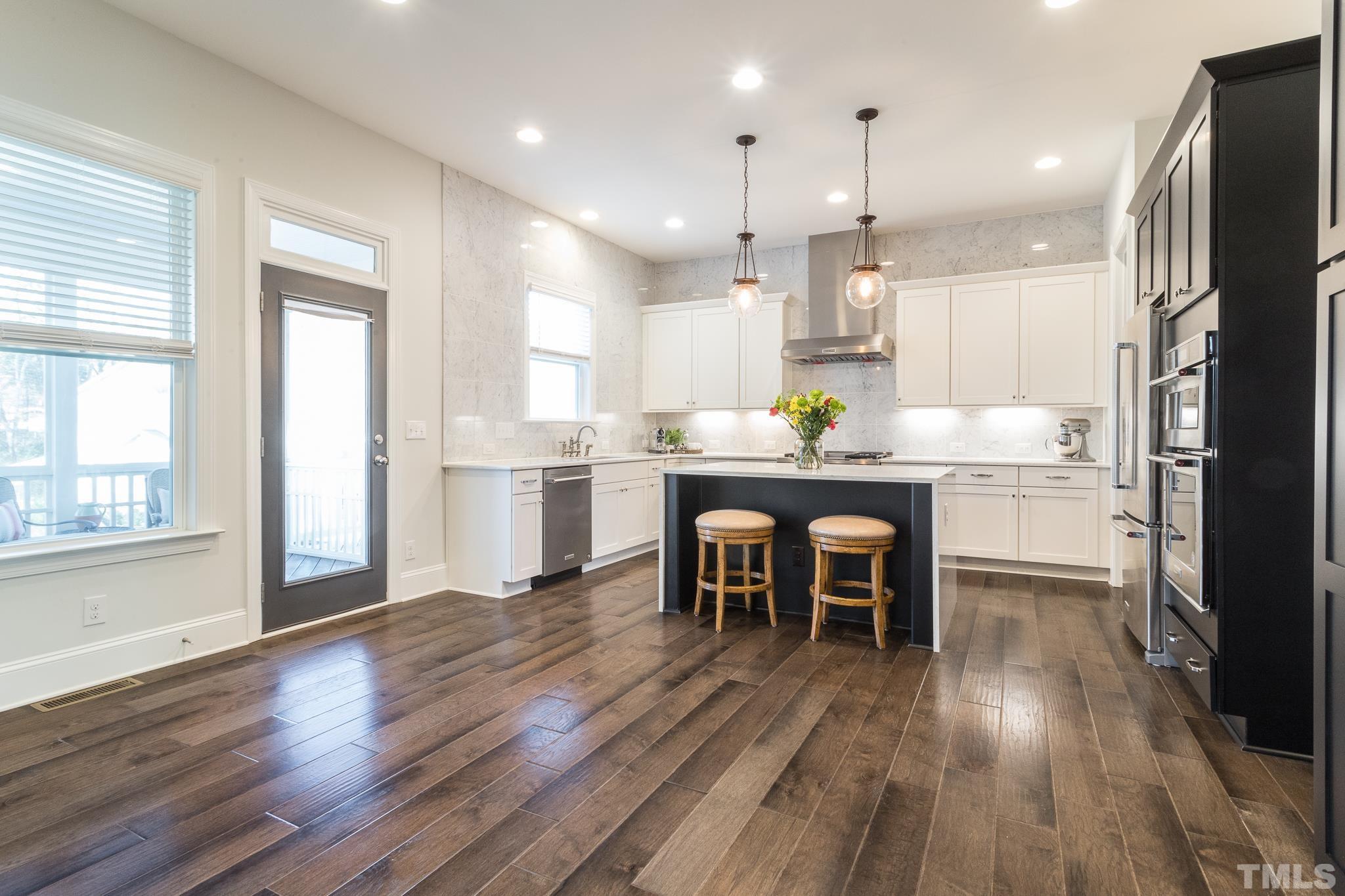 5601 Norcrest Street Raleigh, NC 27612 - Photo 8 of 41 a dining room with stainless steel appliances granite countertop furniture wooden floor and a kitchen view