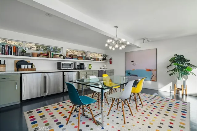 a view of a dining room with furniture one side kitchen view and wooden floor