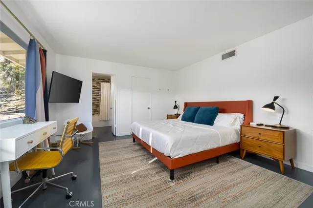 a bedroom with two beds lamp and a large window