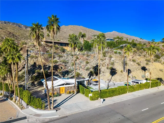 an aerial view of a house with a yard and large trees