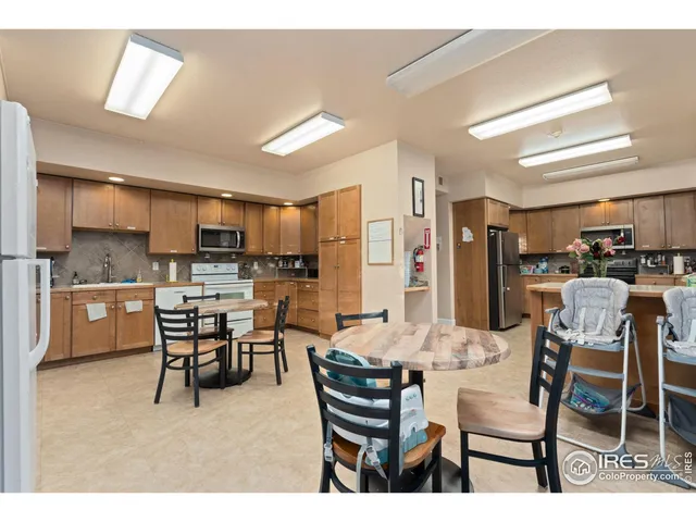 a dining area with stainless steel appliances kitchen island granite countertop a dining table chairs and view living room