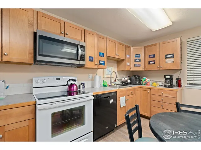 a kitchen with stainless steel appliances kitchen island granite countertop a stove top oven microwave and cabinets