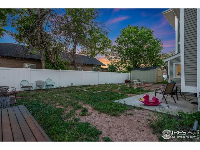 a backyard of a house with table and chairs