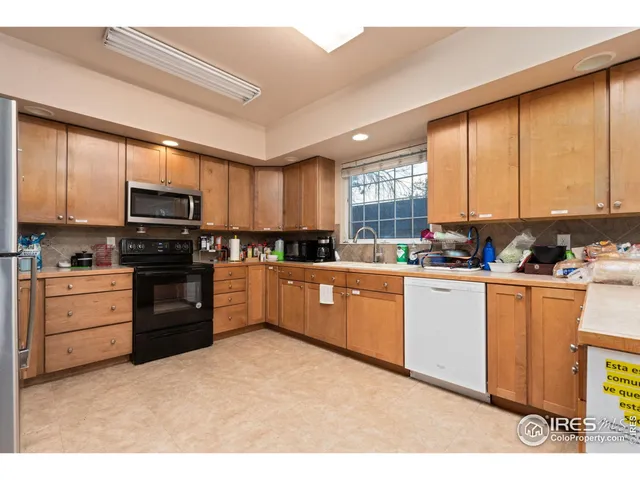 a kitchen with stainless steel appliances granite countertop a stove top oven a sink dishwasher a refrigerator and cabinets with wooden floor