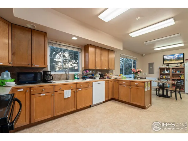 a large kitchen with kitchen island granite countertop a stove a sink a dining table and chairs
