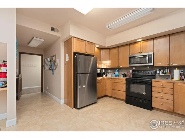 a kitchen with granite countertop a refrigerator stove and microwave