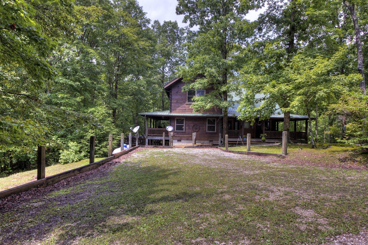 340 Doe Ridge Road Oneida, TN 37841 - Photo 38 of 40 a view of a swimming pool with a table and chairs under an umbrella