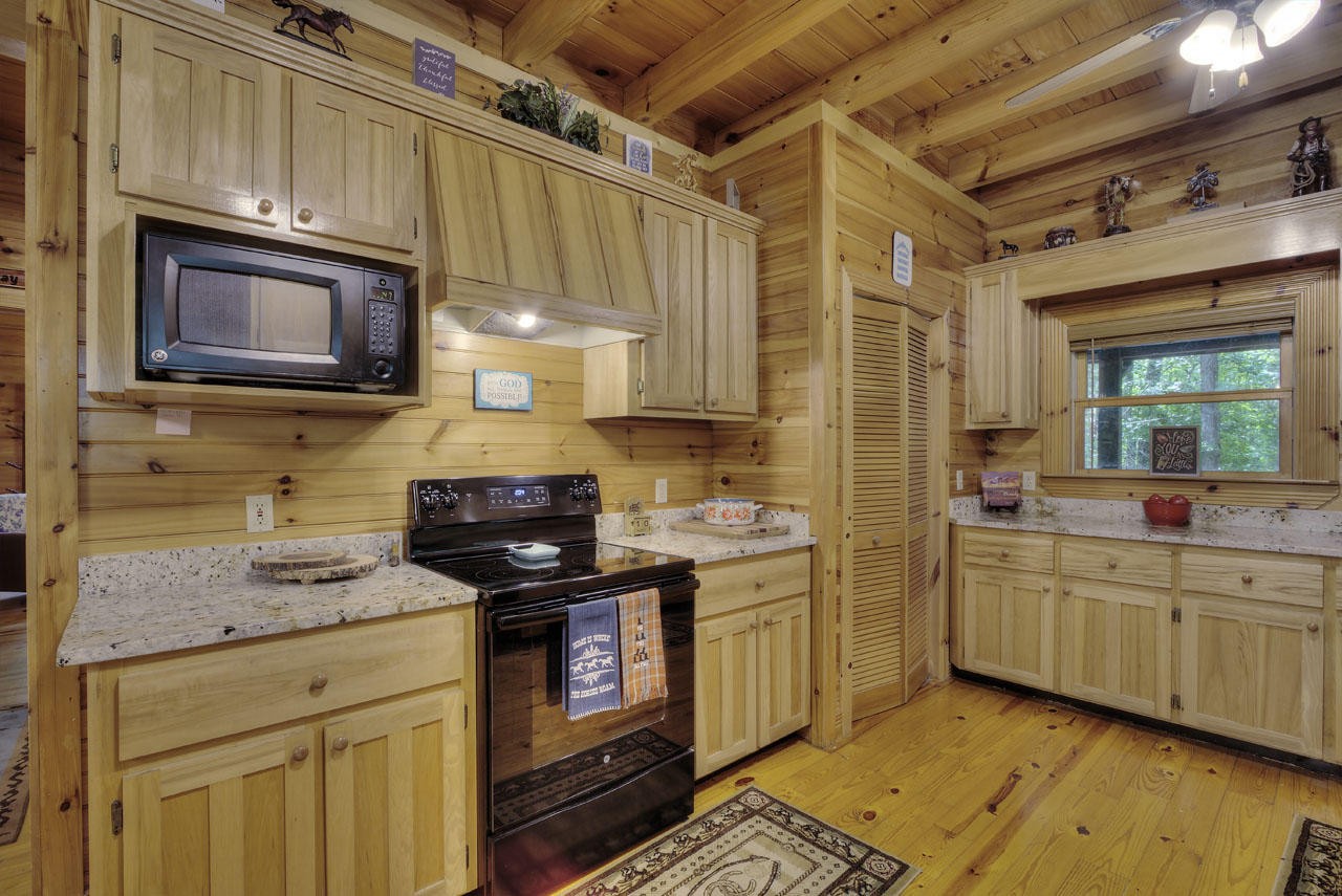 340 Doe Ridge Road Oneida, TN 37841 - Photo 9 of 40 a kitchen with stainless steel appliances granite countertop a stove a sink and a microwave