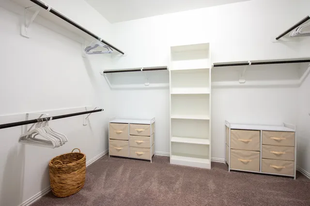 a view of walk in closet with clothes