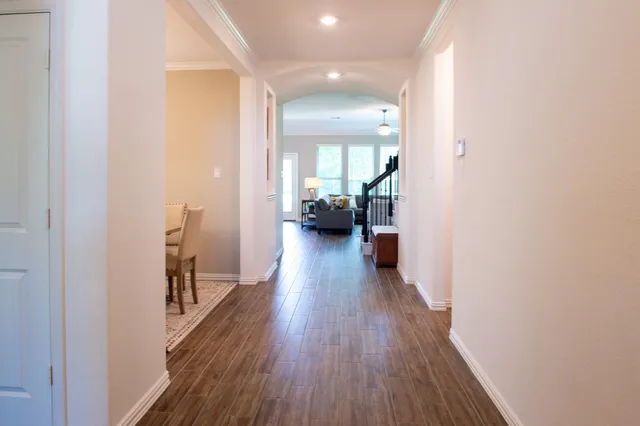 a view of a hallway with wooden floor and furniture