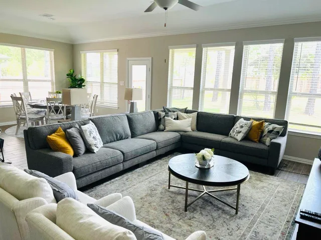a living room with furniture wooden floor and a large window