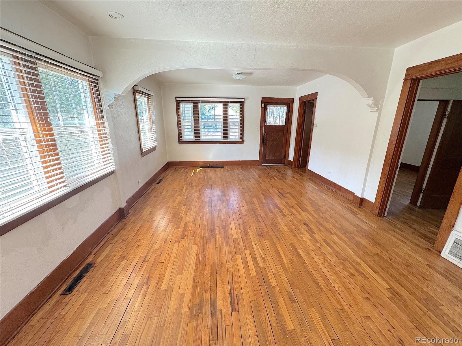 322 3rd Street Frederick, CO 80530 - Photo 13 of 30 a view of an empty room with wooden floor and a window