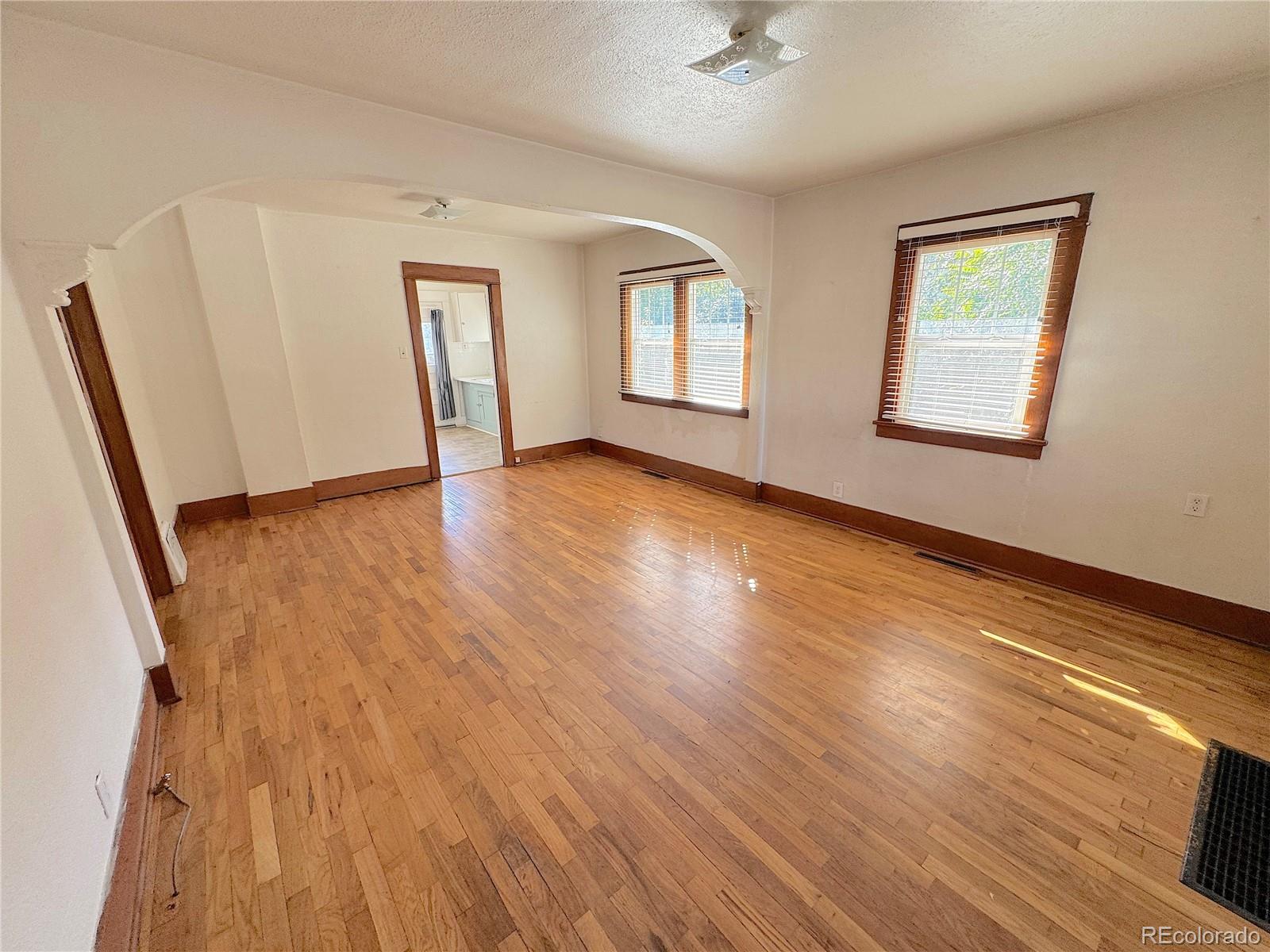 322 3rd Street Frederick, CO 80530 - Photo 14 of 30 a view of an empty room with wooden floor and a window