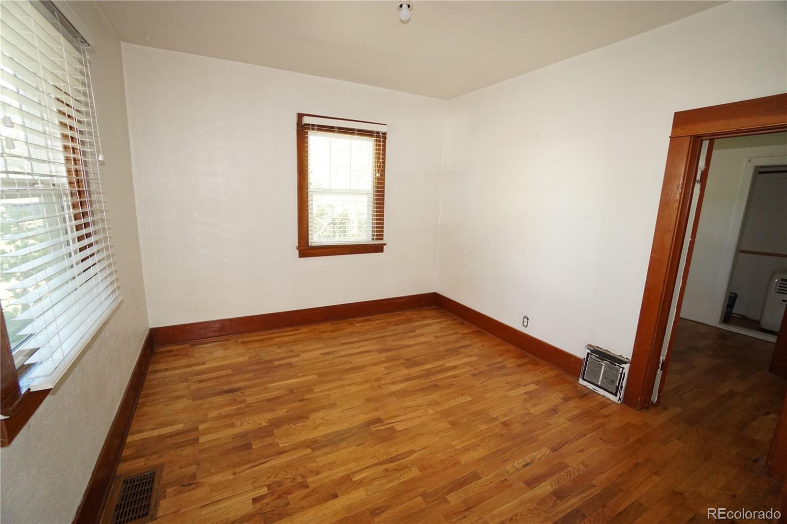 322 3rd Street Frederick, CO 80530 - Photo 15 of 30 an empty room with wooden floor and windows