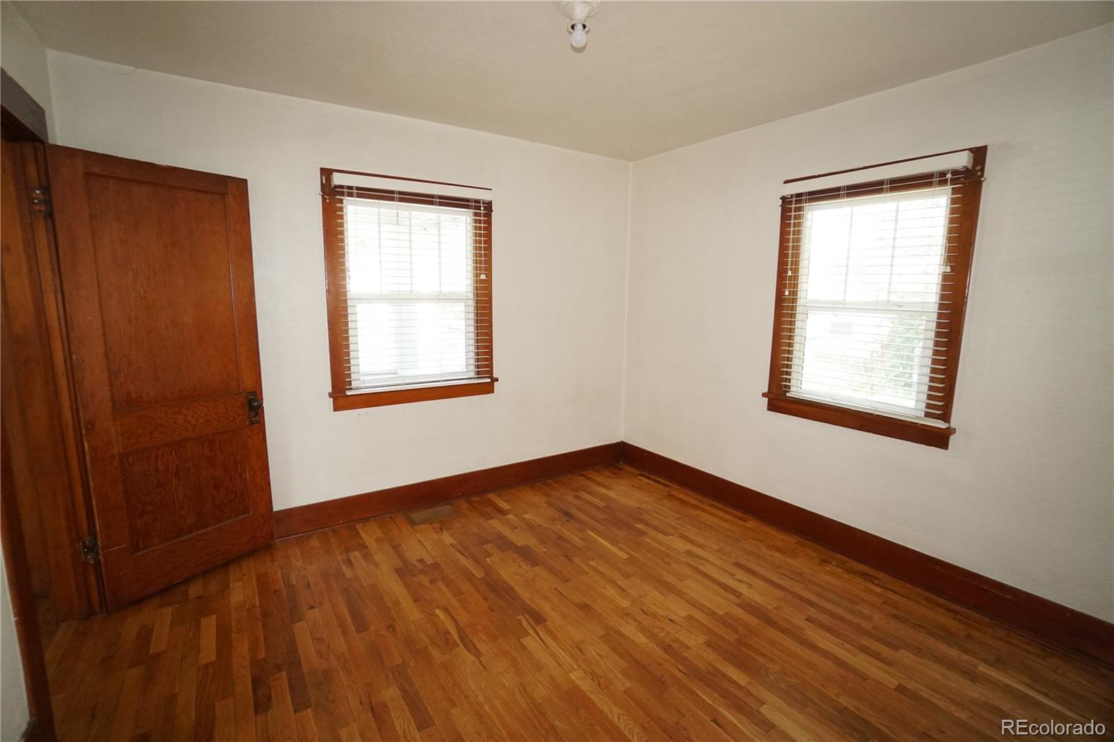 322 3rd Street Frederick, CO 80530 - Photo 17 of 30 a view of an empty room with wooden floor and a window