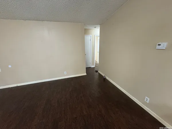 a view of an empty room with wooden floor