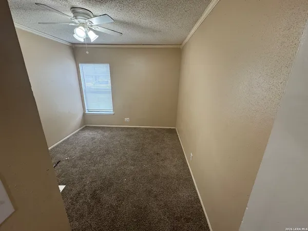 en empty room with wooden floor and chandelier fan